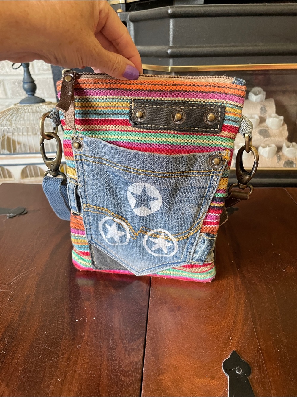 Small denim Travelteli crossbody with multi colored stripes on front